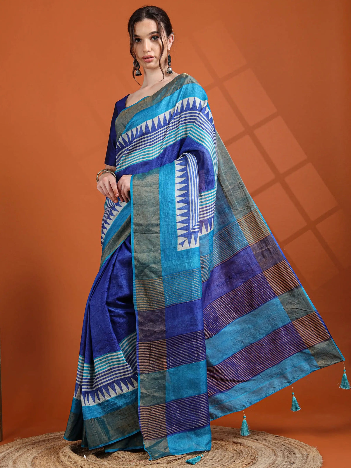 Saree: navy tussar silk with turquoise contrast stripes and tasselled border, worn by model.